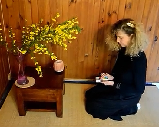 Anne vincent entrain d'allumer la bougie avant la méditation zen